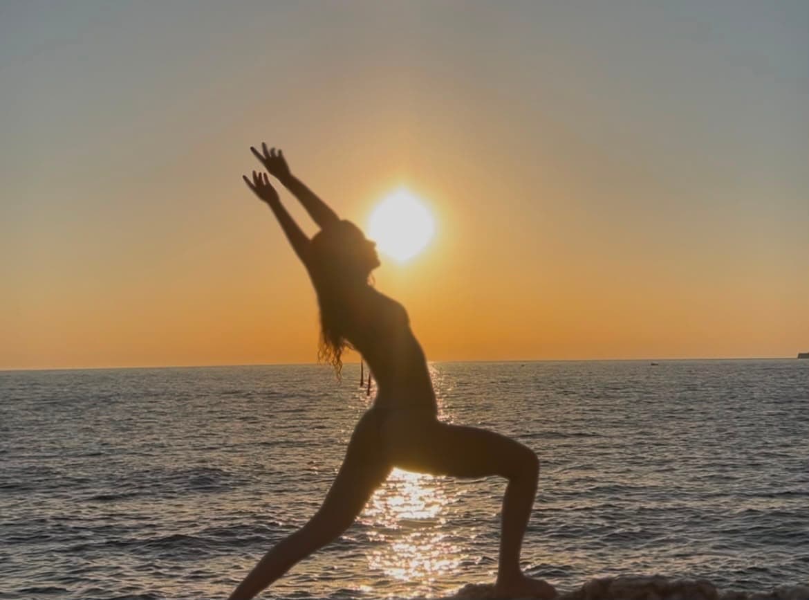 Woman practising yoga at sunset